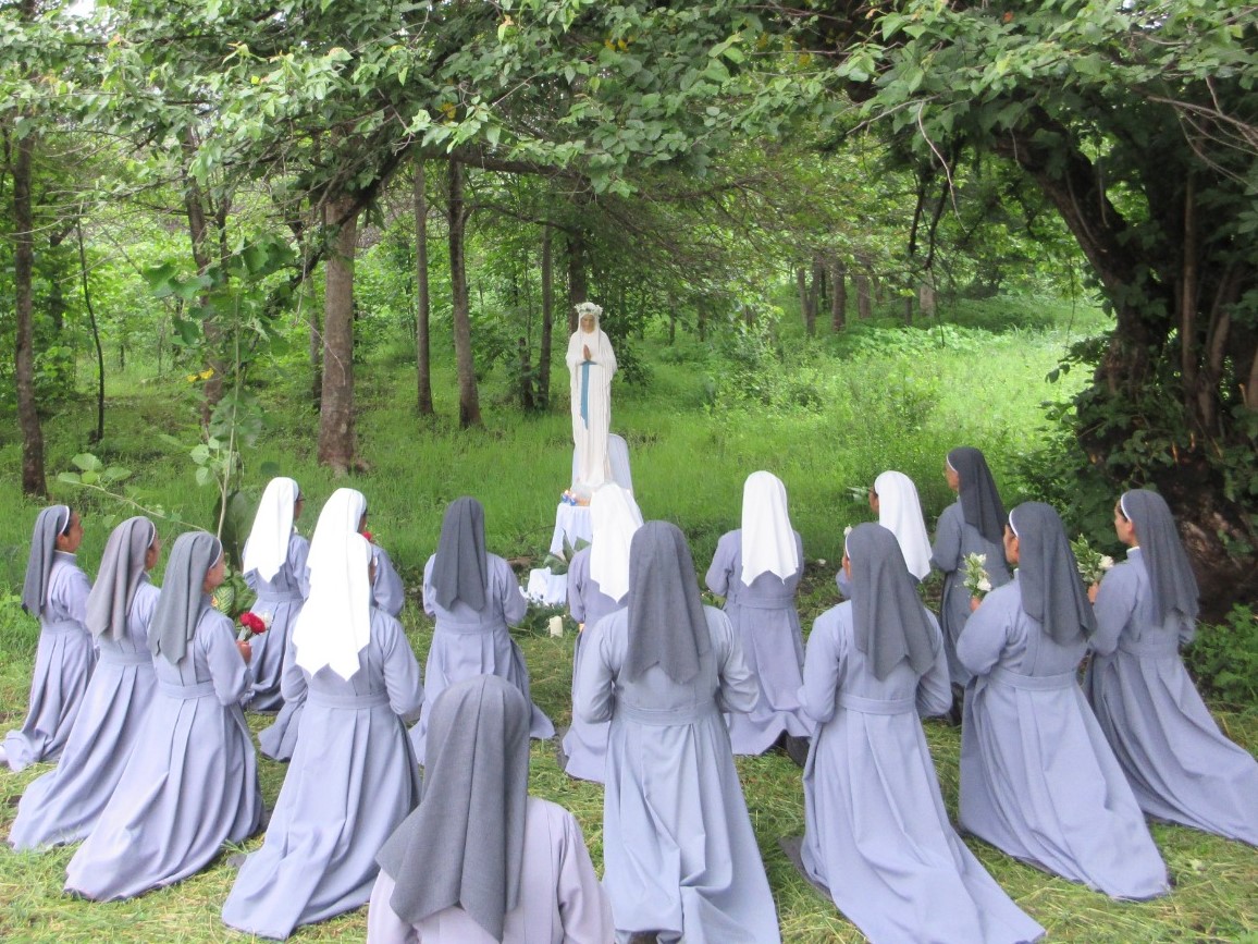 Sisters praying to the Virgin of the Poor Sisters praying the rosary