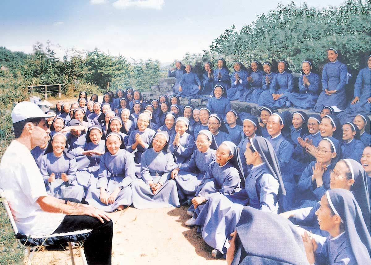 Sisters of Mary in Korea seated outdoors during a group gathering with Father Al.