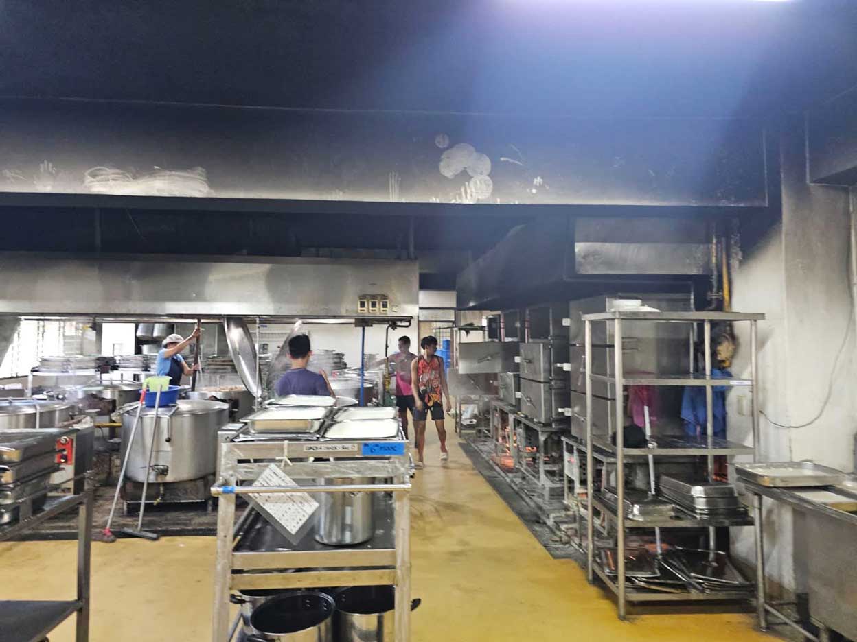 Workers prepare meals in the aging industrial kitchen at the Sisters of Mary Boystown in Minglanilla, Philippines.