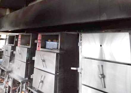 Aging industrial ovens and a large ventilation hood inside the kitchen at Minglanilla Boystown.